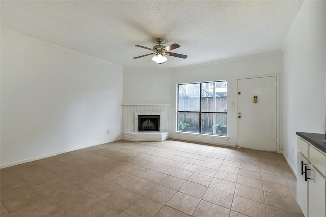 1100 Augusta Dr Unit 33, Houston, TX 77057 - unfurnished living room featuring ceiling fan, a textured ceiling, light tile patterned floors, a fireplace, and crown molding