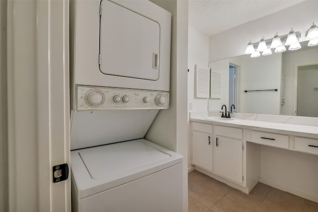 1100 Augusta Dr Unit 33, Houston, TX 77057 - laundry room with stacked washing machine and dryer, light tile patterned flooring, and a textured ceiling