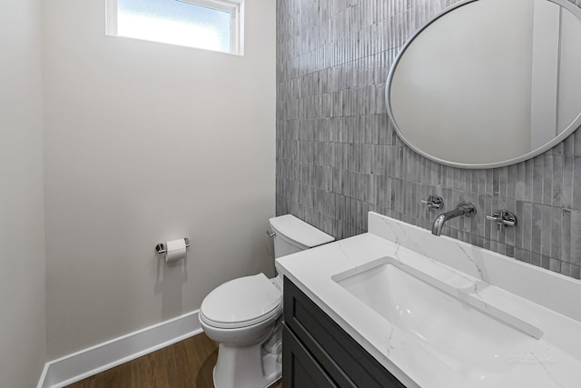 4224 Buck St, Houston, TX 77020 - half bathroom with toilet, tile walls, vanity, wood finished floors, and baseboards