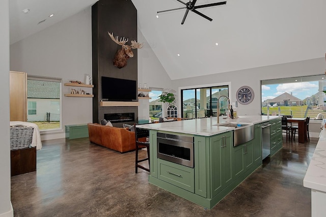 12595 St Louis Ct, Willis, TX 77318 - kitchen featuring green cabinetry, a sink, high vaulted ceiling, stainless steel microwave, and concrete flooring