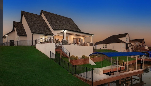 12595 St Louis Ct, Willis, TX 77318 - rear view of house featuring stucco siding, stairs, and boat lift