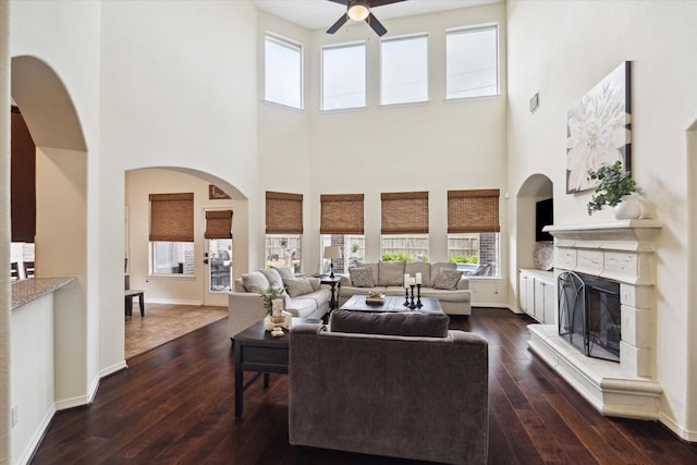 8718 Stowe Creek Ln, Missouri City, TX 77459 - living room featuring ceiling fan, a high ceiling, dark wood-style floors, healthy amount of natural light, and baseboards
