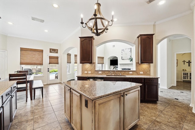 8718 Stowe Creek Ln, Missouri City, TX 77459 - kitchen with a sink, a chandelier, a center island, decorative backsplash, and ornamental molding