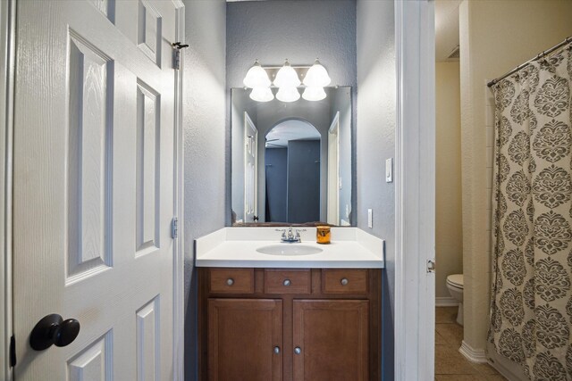 8718 Stowe Creek Ln, Missouri City, TX 77459 - bathroom featuring toilet, tile patterned floors, vanity, a textured wall, and a shower with shower curtain