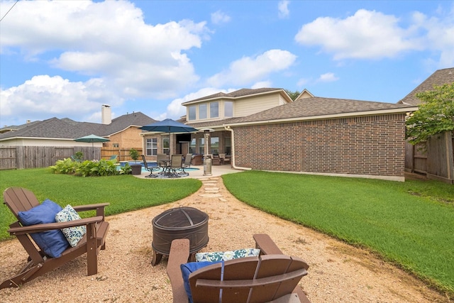 8718 Stowe Creek Ln, Missouri City, TX 77459 - rear view of house with an outdoor fire pit, brick siding, a patio area, and a shingled roof