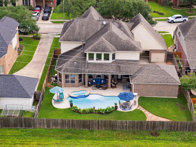 8718 Stowe Creek Ln, Missouri City, TX 77459 - rear view of house featuring roof with shingles, a patio, a pool with connected hot tub, an outdoor hangout area, and brick siding
