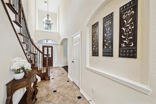 8718 Stowe Creek Ln, Missouri City, TX 77459 - tiled entrance foyer featuring arched walkways, a chandelier, stairway, baseboards, and a towering ceiling