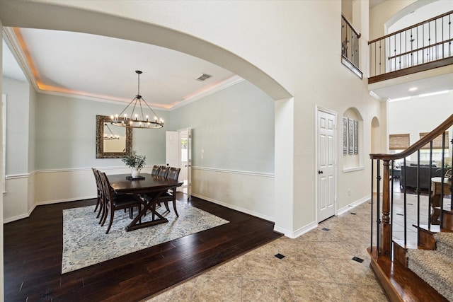 8718 Stowe Creek Ln, Missouri City, TX 77459 - dining room with arched walkways, stairway, hardwood / wood-style floors, a chandelier, and crown molding