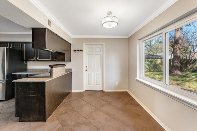 10134 Hanka Dr, Houston, TX 77043 - kitchen featuring freestanding refrigerator, crown molding, light tile patterned flooring, and baseboards