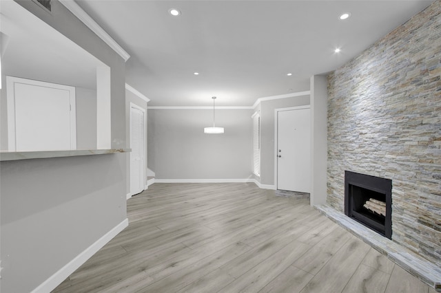 17202 Imperial Valley Dr Unit 16, Houston, TX 77060 - unfurnished living room with crown molding, a stone fireplace, baseboards, wood finished floors, and recessed lighting