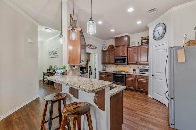 911 Dove Run Trl, College Station, TX 77845 - kitchen with stainless steel appliances, a peninsula, crown molding, dark wood-style floors, and tasteful backsplash
