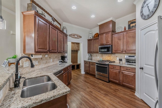 911 Dove Run Trl, College Station, TX 77845 - kitchen featuring appliances with stainless steel finishes, a sink, ornamental molding, decorative backsplash, and dark wood finished floors
