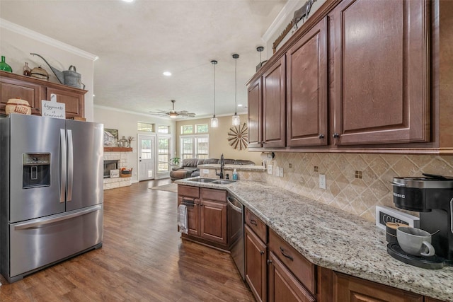 911 Dove Run Trl, College Station, TX 77845 - kitchen with appliances with stainless steel finishes, crown molding, a sink, a fireplace, and decorative backsplash