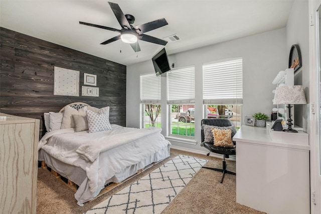 911 Dove Run Trl, College Station, TX 77845 - bedroom with an accent wall, an office area, light carpet, a ceiling fan, and wooden walls