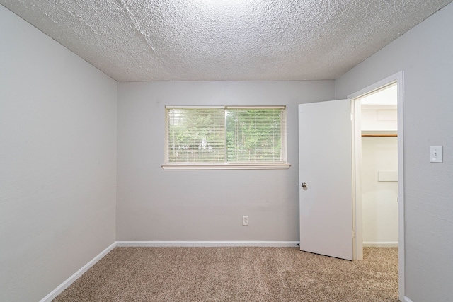 8006 Barnhill Dr, Humble, TX 77338 - unfurnished room with light colored carpet, a textured ceiling, and baseboards