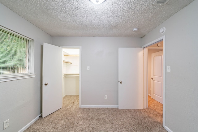 8006 Barnhill Dr, Humble, TX 77338 - unfurnished bedroom with carpet floors, a spacious closet, a textured ceiling, and a closet