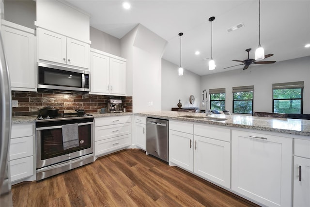 3148 Poe Dr, Montgomery, TX 77356 - kitchen with appliances with stainless steel finishes, a sink, tasteful backsplash, dark wood-style flooring, and white cabinets