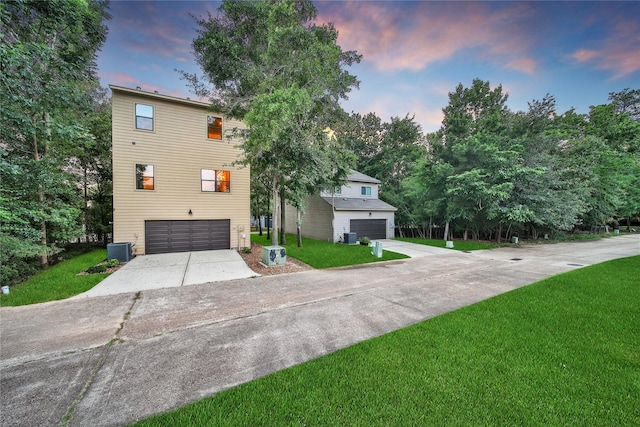 3148 Poe Dr, Montgomery, TX 77356 - view of front of house featuring an attached garage, concrete driveway, a lawn, and central air condition unit