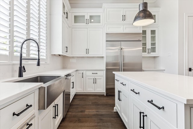 3850 Glen Arbor Dr, Houston, TX 77025 - kitchen with appliances with stainless steel finishes, a sink, white cabinets, hanging light fixtures, and dark wood-type flooring