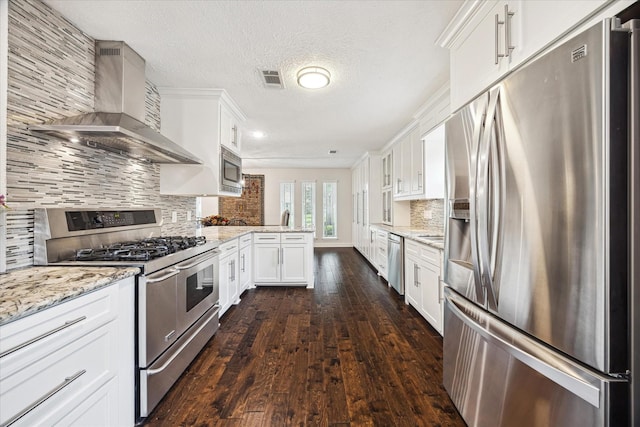 2714 Fontana Dr, Houston, TX 77043 - kitchen featuring appliances with stainless steel finishes, wall chimney range hood, a peninsula, dark wood finished floors, and tasteful backsplash