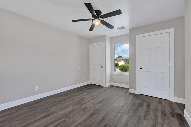 9805 Fabiola Dr, Houston, TX 77075 - unfurnished bedroom featuring dark wood-style floors, baseboards, and ceiling fan
