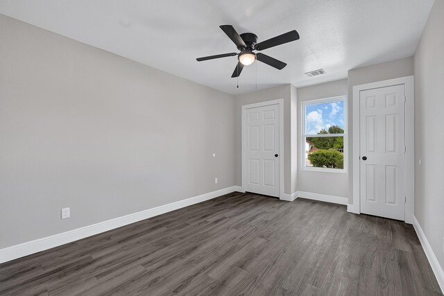 9805 Fabiola Dr, Houston, TX 77075 - unfurnished bedroom featuring dark wood-type flooring, baseboards, and a ceiling fan