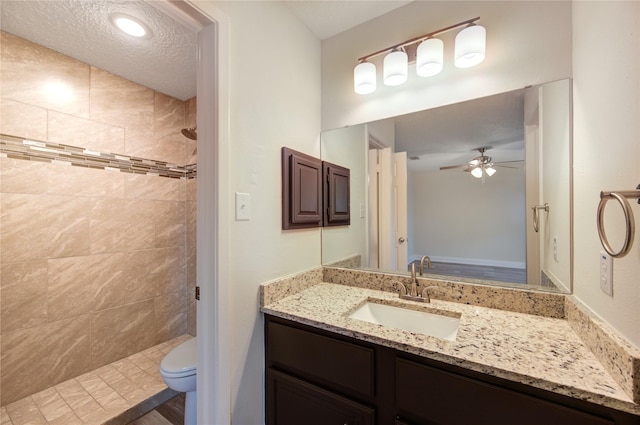 14011 Dominique Dr, Cypress, TX 77429 - bathroom with tiled shower, toilet, a ceiling fan, and vanity