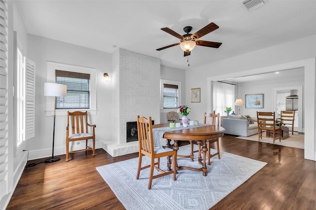 1618 Lawrence St, Houston, TX 77008 - dining room featuring a ceiling fan, dark wood-style floors, a brick fireplace, and baseboards