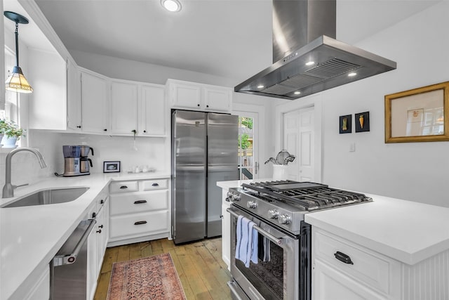 1618 Lawrence St, Houston, TX 77008 - kitchen with island range hood, appliances with stainless steel finishes, a sink, light wood-style floors, and light countertops