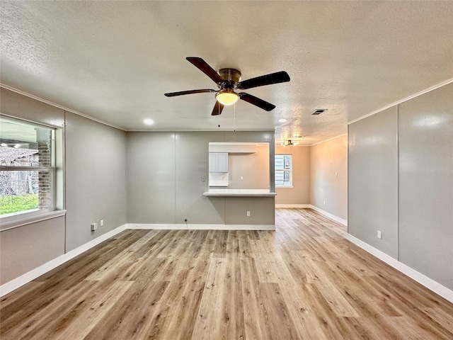 7845 Bonaire St, Houston, TX 77028 - unfurnished living room with light wood-type flooring, a textured ceiling, crown molding, a ceiling fan, and baseboards