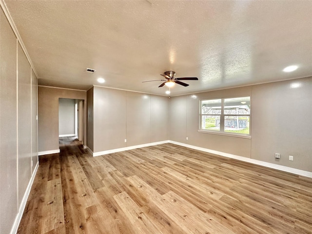 7845 Bonaire St, Houston, TX 77028 - spare room featuring light wood-type flooring, ornamental molding, a ceiling fan, baseboards, and a textured ceiling