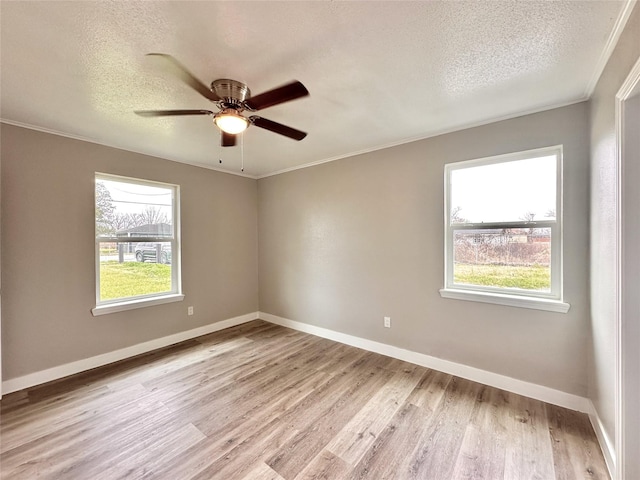7845 Bonaire St, Houston, TX 77028 - spare room with healthy amount of natural light, a textured ceiling, light wood finished floors, ornamental molding, and ceiling fan