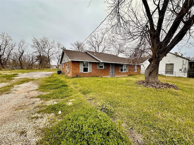 7845 Bonaire St, Houston, TX 77028 - view of front of home featuring dirt driveway, brick siding, a front yard, and cooling unit