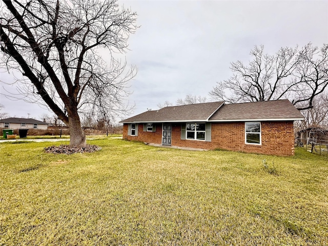 7845 Bonaire St, Houston, TX 77028 - rear view of property with a yard, brick siding, and roof with shingles