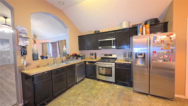 19726 Imperial Colony Ln, Katy, TX 77449 - kitchen with appliances with stainless steel finishes, vaulted ceiling, a sink, arched walkways, and light countertops