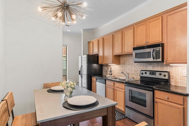 118 Mcgowen St Unit E, Houston, TX 77006 - kitchen with appliances with stainless steel finishes, a sink, a chandelier, backsplash, and crown molding