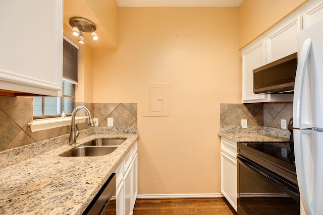 500 Ferry Rd Unit 434D, Galveston, TX 77550 - kitchen with stainless steel microwave, a sink, tasteful backsplash, white cabinetry, and dark wood finished floors
