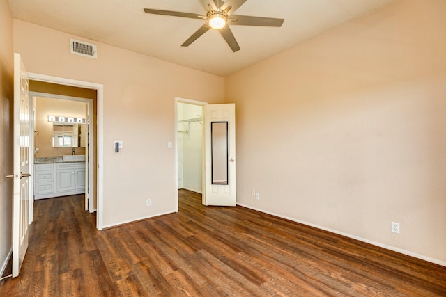 500 Ferry Rd Unit 434D, Galveston, TX 77550 - unfurnished bedroom featuring dark wood finished floors, a walk in closet, baseboards, and a closet