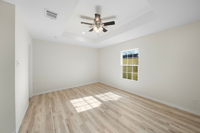 305 E Humble St, Baytown, TX 77520 - empty room featuring a tray ceiling, ceiling fan, light wood-style flooring, and baseboards