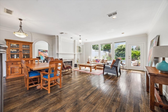 1202 Marconi St, Houston, TX 77019 - dining space with wood finished floors, a fireplace, arched walkways, crown molding, and recessed lighting
