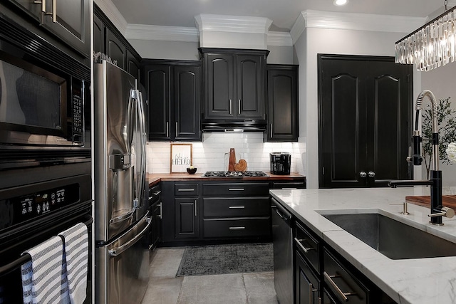 7 Heathcote Ct, The Woodlands, TX 77380 - kitchen with black appliances, a sink, dark cabinets, tasteful backsplash, and light stone counters