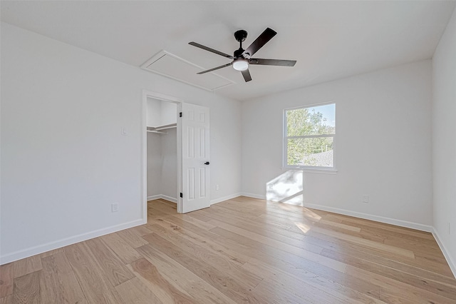 2414 Walnut Bend Ln, Houston, TX 77042 - unfurnished bedroom featuring attic access, light wood-style floors, baseboards, and a walk in closet