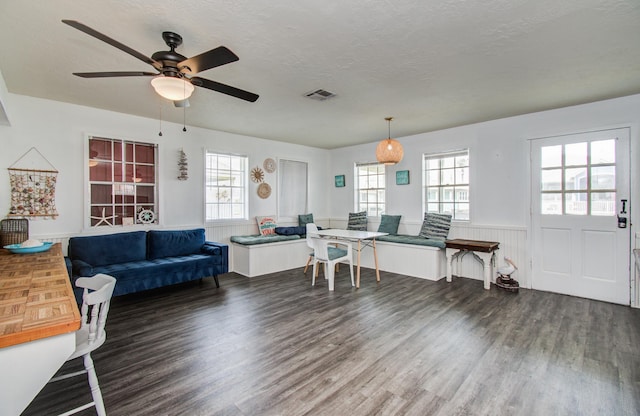 21735 Matagorda Dr, Galveston, TX 77554 - living room featuring wood finished floors, a wainscoted wall, a ceiling fan, and a textured ceiling