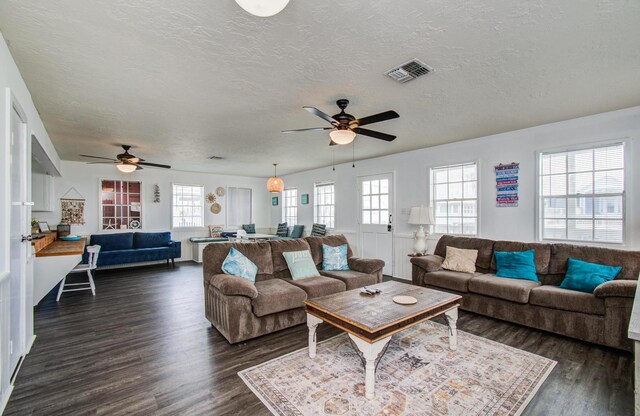 21735 Matagorda Dr, Galveston, TX 77554 - living room featuring ceiling fan, plenty of natural light, dark wood-style floors, and a textured ceiling