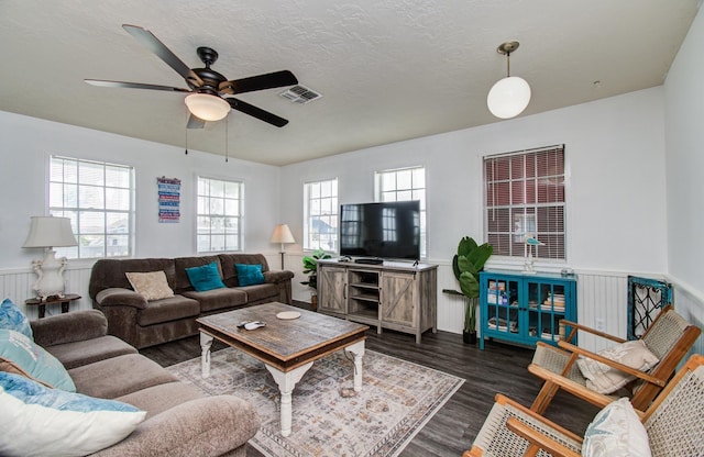21735 Matagorda Dr, Galveston, TX 77554 - living room featuring ceiling fan, dark wood-type flooring, wainscoting, and a textured ceiling