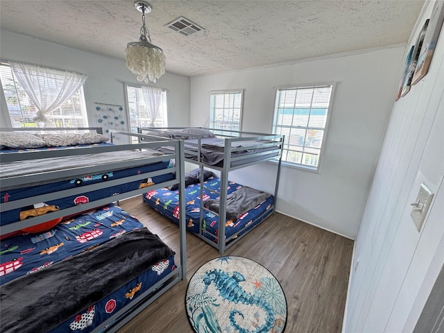 21735 Matagorda Dr, Galveston, TX 77554 - bedroom with a textured ceiling, wood finished floors, and a chandelier