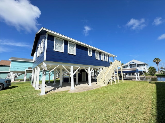 21735 Matagorda Dr, Galveston, TX 77554 - back of property featuring stairs, a lawn, and a water view