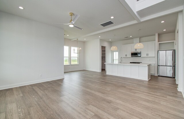 25814 Bay Breeze Dr, Galveston, TX 77554 - unfurnished living room with recessed lighting, light wood finished floors, a chandelier, ceiling fan, and baseboards