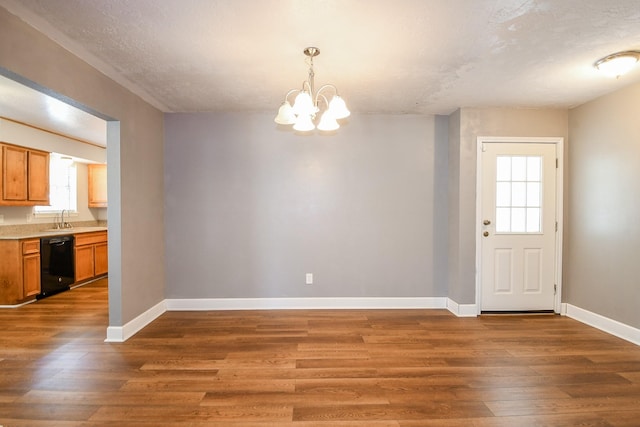 25635 Glen Loch Dr, Spring, TX 77380 - unfurnished dining area with healthy amount of natural light, baseboards, wood finished floors, a chandelier, and a textured ceiling