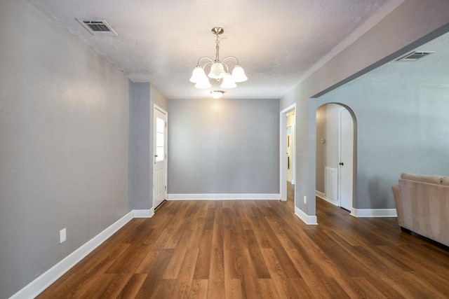 25635 Glen Loch Dr, Spring, TX 77380 - unfurnished room with arched walkways, baseboards, a chandelier, wood finished floors, and a textured ceiling